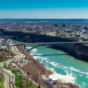 A vibrant river flows through a bustling city, surrounded by modern architecture and natural scenery.