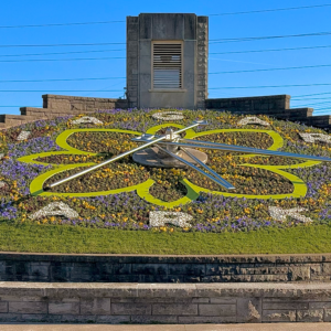 The colorful floral design, shaped like a flower, is centered around a large set of clock hands, proudly displaying the Niagara Parks name.