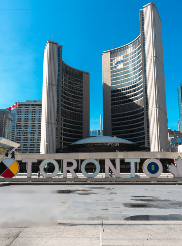 A large building featuring a prominent sign that reads "Toronto" against a clear sky.